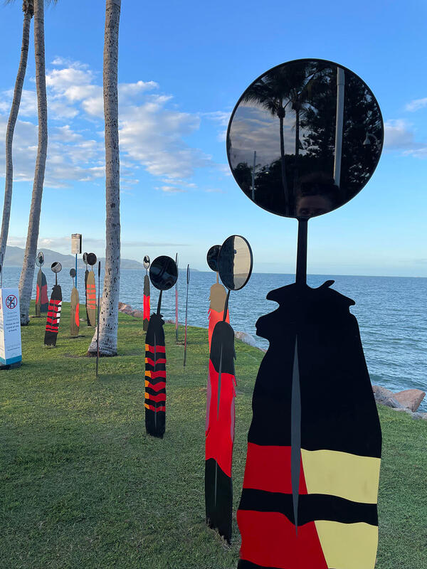 a row of sculptures next to the ocean