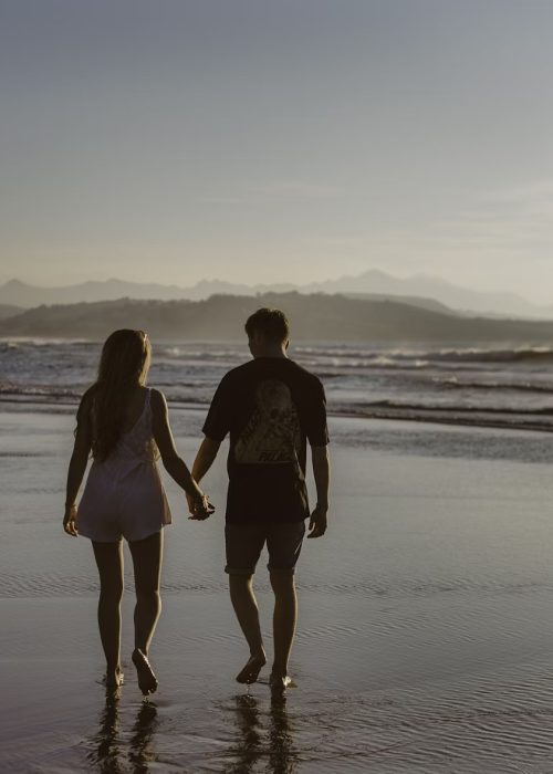 Couple holding hands on Byron Bay Beach